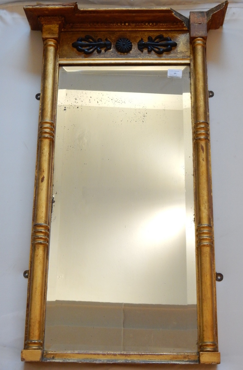 A Regency gilt wood and gesso pier mirror, the frieze with applied foliate design centred by