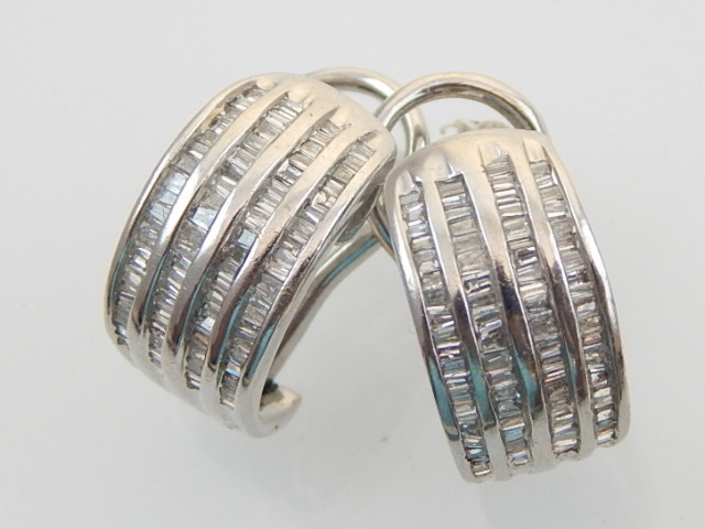 A pair of diamond set half hoop ear clips, with four rows of cannel set stones, set in white metal