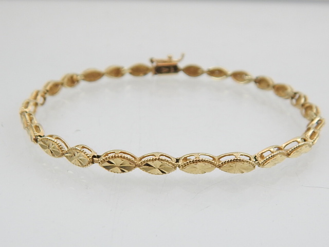 A yellow metal line bracelet, with lozenge shaped bright-cut links, clasp stamped 14K., 4.5 g. - Image 2 of 2