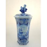 A Delft pottery vase of hexagonal form, the cover with lion knop over a waisted body, decorated with