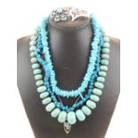 A graduated turquoise bead necklace with white metal clasp,