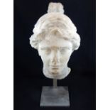 After the antique, a stone marble head of possibly Aphrodite, raised on stand, H.