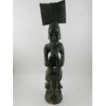 A 20th century West African carved ancestor figure of a women kneeling on three other figures. H.