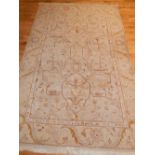 A cream ground Ziegler rug, decorated with floral spandrels, fringed.