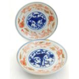 A pair of 20th century Chinese porcelain saucers, decorated with blue foliage to centre within