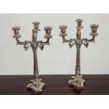 A pair of plated Empire style three branch candelabra, the Corinthian column raised on three pad