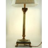 A brass table lamp, Corinthian column base, set on square marble base, raised on paw feet.