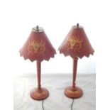 A pair of reproduction red toleware table lamps the floral, gilt scroll decorated shades on
