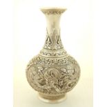 A Chinese white metal baluster shape vase with everted rim, decorated in low relief with vignettes