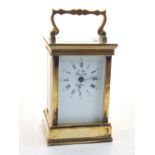 A French brass carriage clock, the white enamel dial with Roman numerals, outer minute track with