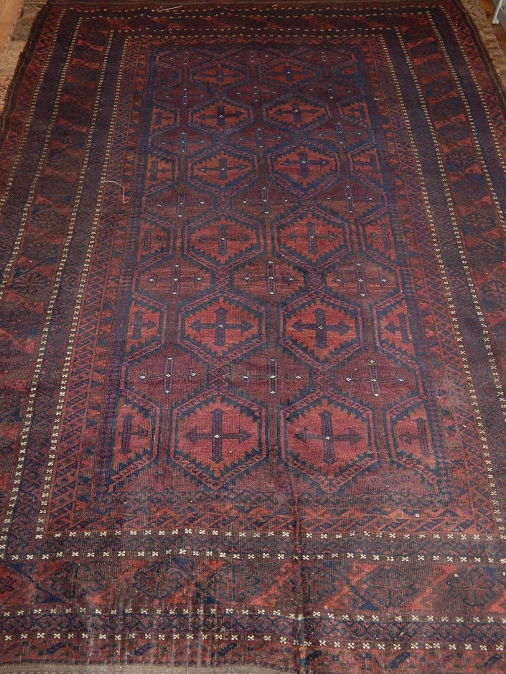 A Baluch carpet, decorated with octagonal medallions to centre within reticulated borders, fringed. - Image 2 of 3