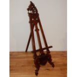 A reproduction Victorian design mahogany easel with pierced scroll pediment. H.