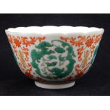 A Chinese porcelain tea bowl, polychrome decorated with vignettes of scrolling foliage,