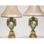 A pair of Victorian style glazed pottery table lamps and shades, decorated with rural landscapes. H.