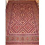 A red ground Pakistani rug, of geometric square design, fringed.