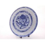 An early 20th century Chinese saucer dish, blue glass, dragon to centre,