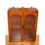 A small Victorian glazed mahogany two door wall cabinet, with carved scroll pediment. H.