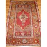 A Turkish Anatolian rug, with teardrop medallion design to centre, floral borders, L.