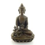 A Chinese patinated bronze of a seated Buddha, H.