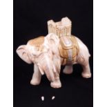 A Crown Devon porcelain elephant centrepiece, modelled standing wearing a green,