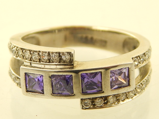 An 18ct white gold amethyst and white stone dress ring tension collet set with open shoulder.