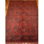 An Afghan Bokhara rug, decorated with two rows of elephant medallions to centre.