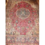 A red ground Tabriz rug of traditional floral design, fringed.