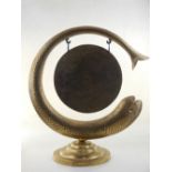 A Benares engraved brass dinner gong, modelled as a coiled eel, on stepped circular base. H. 54cm