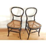 A pair of Victorian ebonised and mother-of-pearl side chairs, with balloon backs and cane seats.