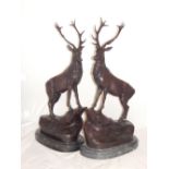 After Jules Moignez, a pair of patinated bronze stags, modelled standing on rocky outcrops,