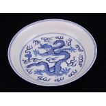 A Chinese blue and white porcelain dish, decorated with dragons chasing faming pearls,