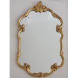 A gilt framed wall mirror, the cartouche shaped frame with foliate border, H. 78cm.