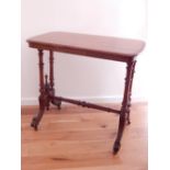 A Victorian walnut centre table, with twin turned supports and down-swept legs joined by a