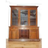 A late Victorian oak library bookcase the glazed upper section over three freize drawers open