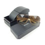 A pair of Prada sunglasses, cased and boxed .