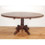 A mid Victorian rosewood Loo table with oval tilt top on wrythen carved pillar and quadruple