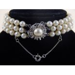 A pearl and white metal multi-strand bracelet, with pearl and white stone set lock.