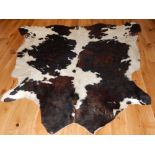 A 20th century cow hide rug, L. 174cm