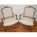 A pair of late 18th early 19th century French beech elbow chairs the painted scroll carved frames