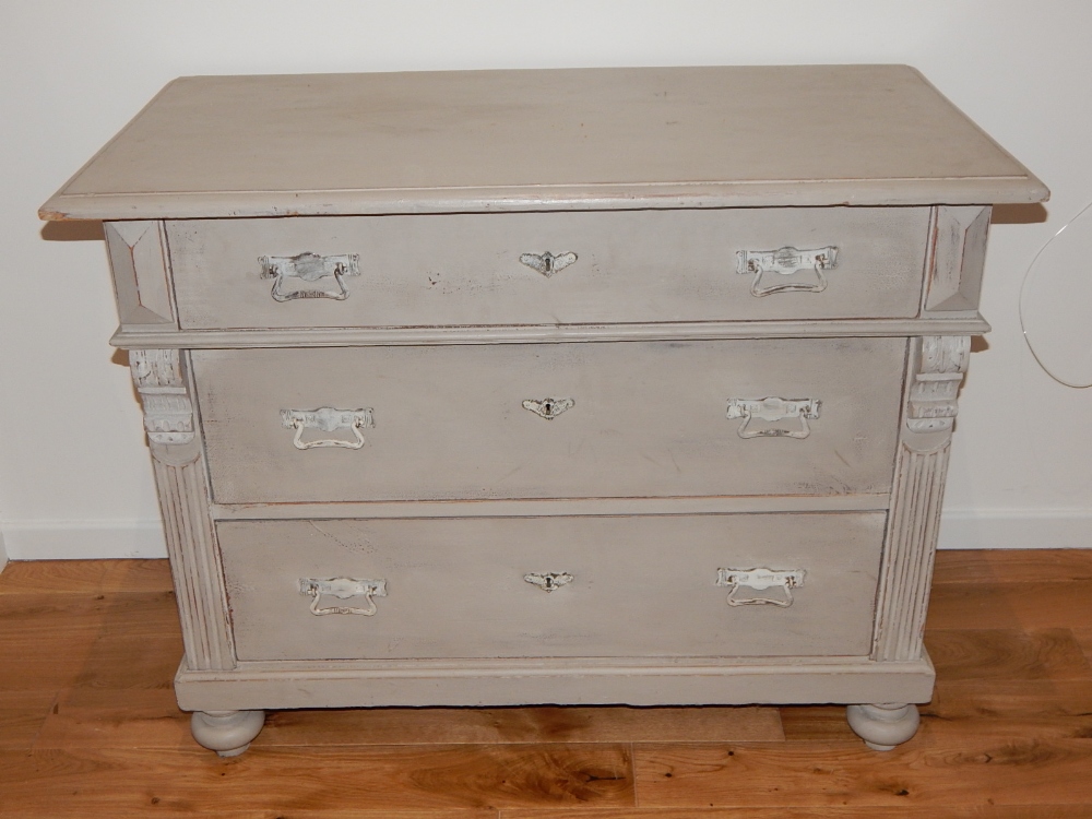 A Victorian chest of drawers, later grey painted, with an arrangement of three drawers flanked by