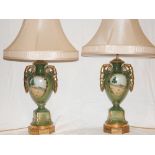 A pair of Victorian style glazed pottery table lamps and shades, decorated with rural landscapes, H.