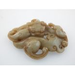A Chinese jade pendant, with a study of a curled temple dragon. L. 7.5cm