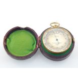 An early 20th century Negretti & Zambra gilt metal pocket barometer combined compass, the circular