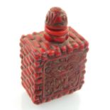 A Chinese red snuff bottle of brick form, with two panels of dragons. H. 7.5cm