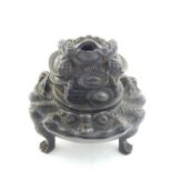 A Chinese bronze tripod koro with toad masks, the cover with a toad sitting on a pile of hats. H.