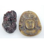 A Chinese spinach jade pendant carving of a god's face, H. 4.8cm, and a red / black jade pendant