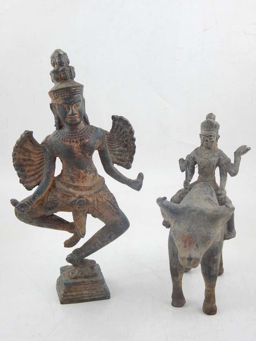 A South East Asian deity, astride a buffalo, H. 19cm, together with another deity (2).