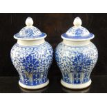 A pair of Ming dynasty style miniature lidded ginger jars, blue and white glass with trailing leaf