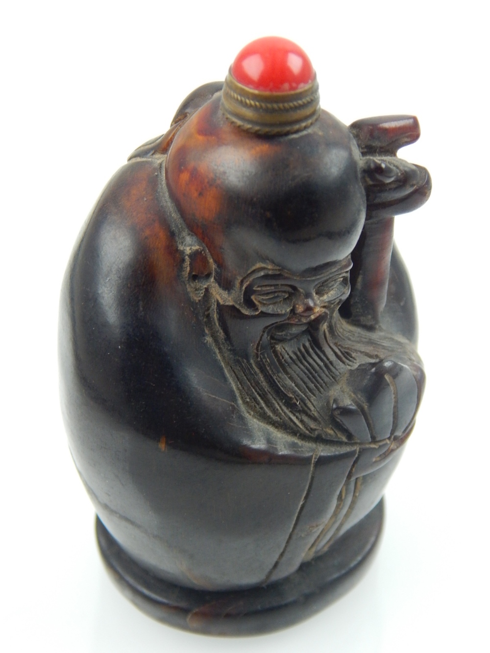 A Chinese horn snuff bottle carved in the form of sage, red jade stopper. H. 7.5cm