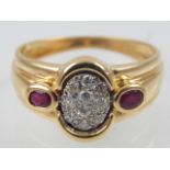 An 18ct yellow gold and diamond cluster ring, set diamonds to centre, flanked by rubies.